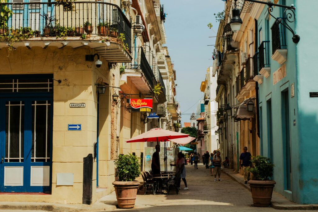 Home Vibrant street in Old Havana, Cuba with colorful buildings and people enjoying the atmosphere.