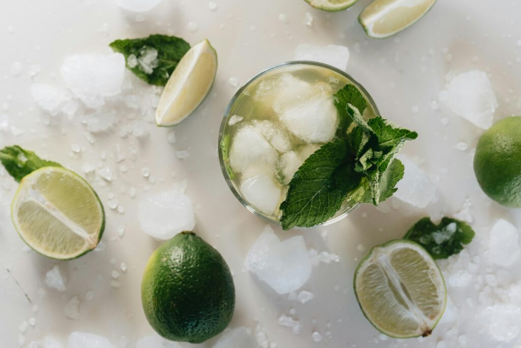 Home Top view of a refreshing mojito with lime and mint, surrounded by ice cubes.